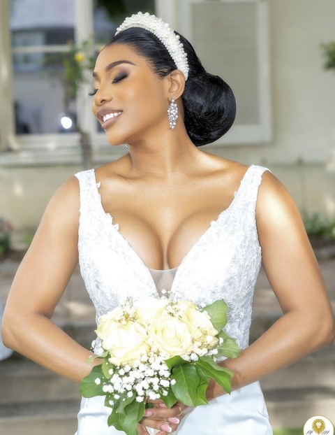 Mariée au chignon avec serre-tête de perles et bouquet blanc